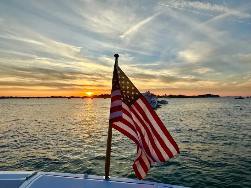American flag on the stern at sunset